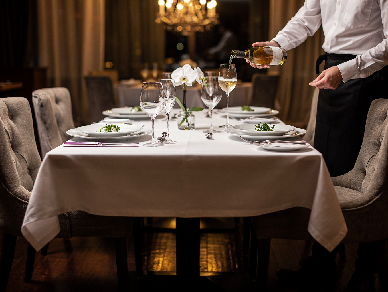 Elegant table setting with linen napkins and fresh herbs